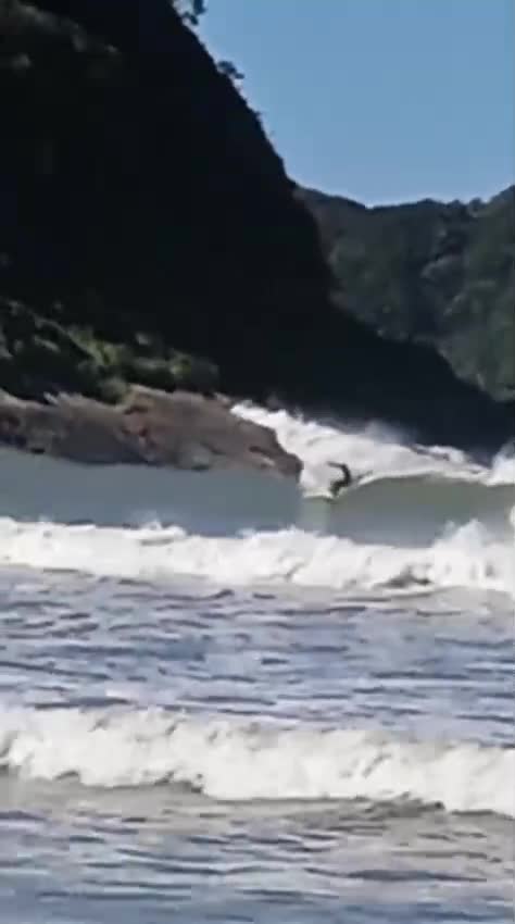 Surfista enfrentando ondas gigantes em praia paradisíaca