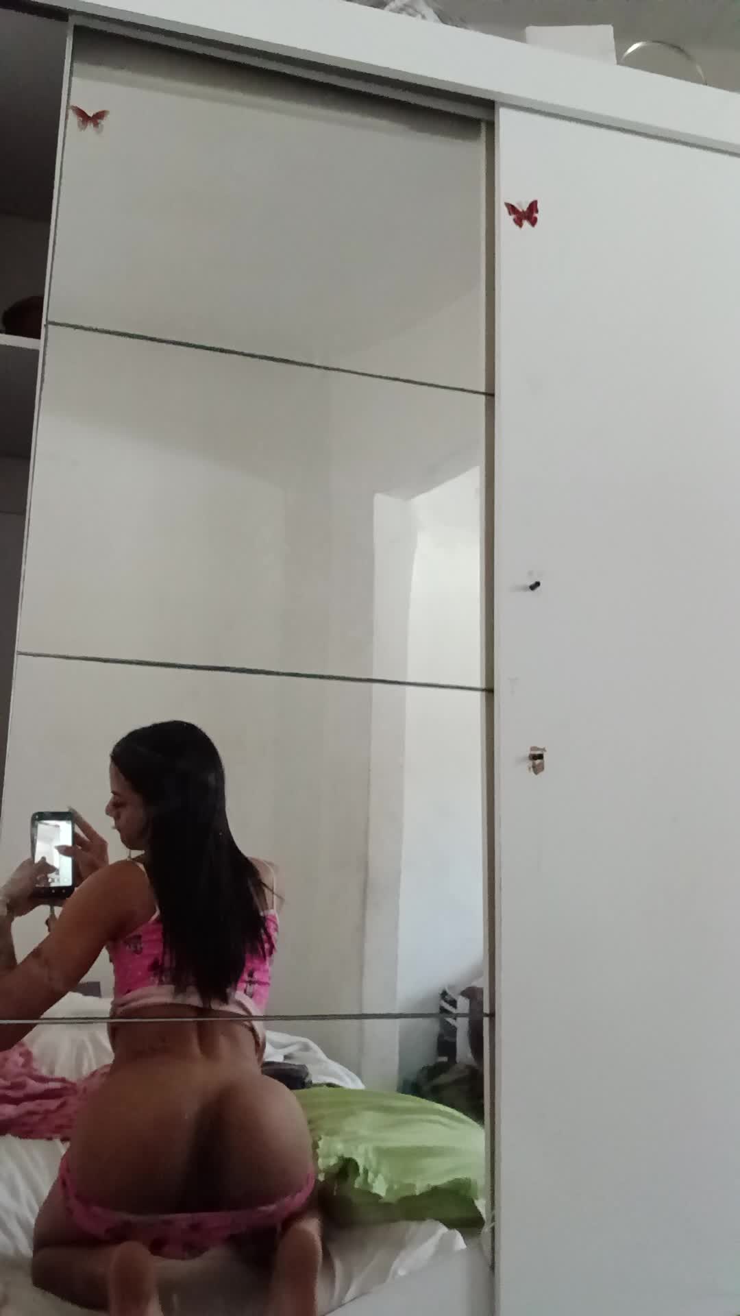 Gostosa de calcinha rosa exibindo a bunda no espelho