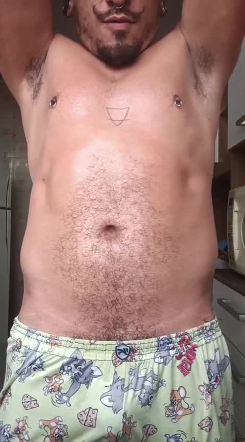 Homem sarado com piercings exibindo peitoral