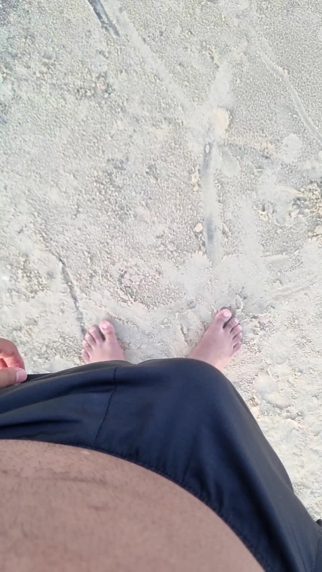 Praia e pés masculinos em destaque