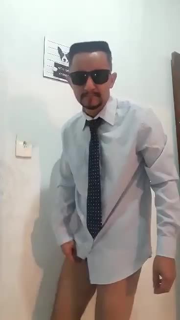 Homem de sunga, camisa social e gravata se masturbando