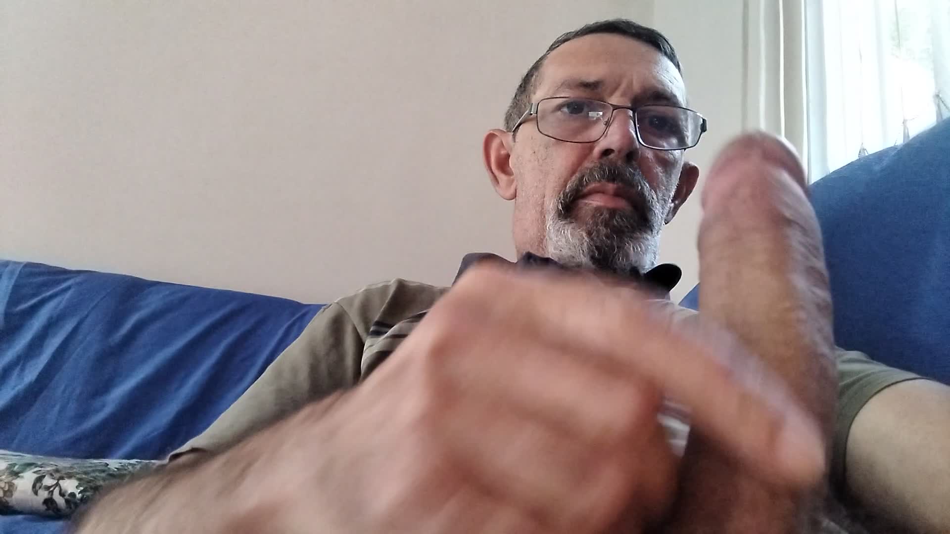 Homem maduro com óculos se masturbando
