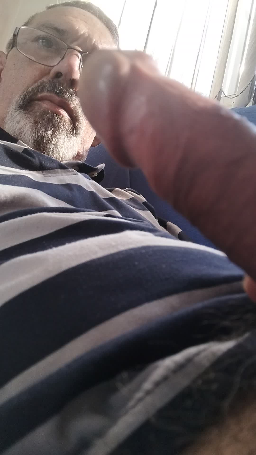 Homem maduro de óculos e barba se masturbando