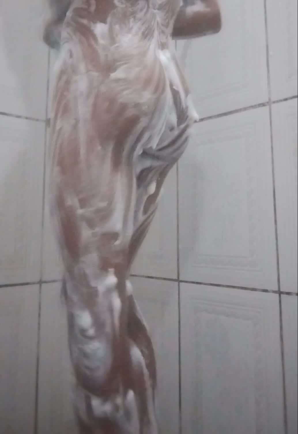 Banho sensual com sabão e corpo bronzeado