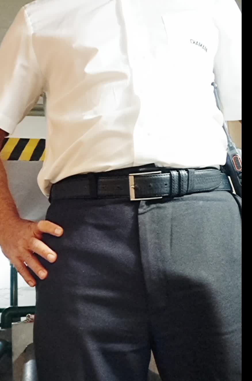 Segurança charmoso em uniforme mostrando volume na calça