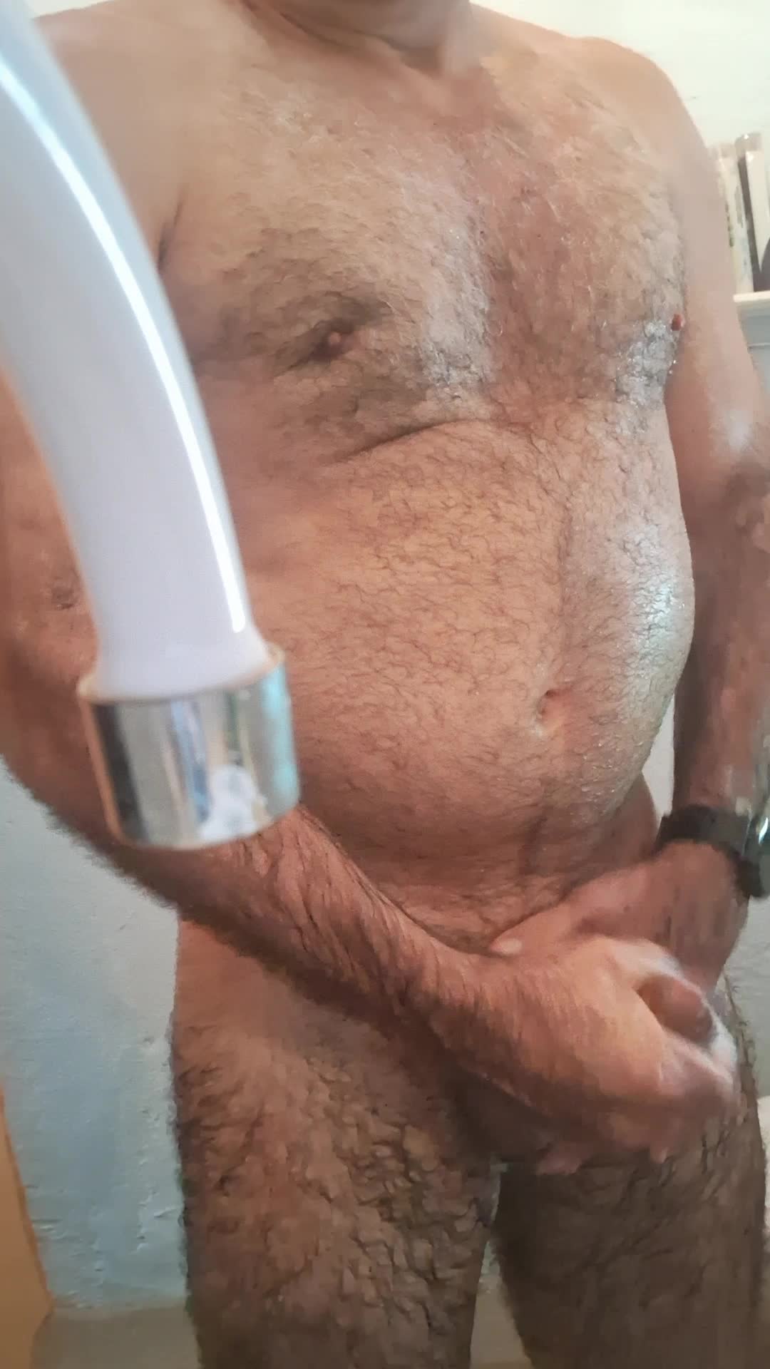 Homem peludo e atlético se masturbando no chuveiro