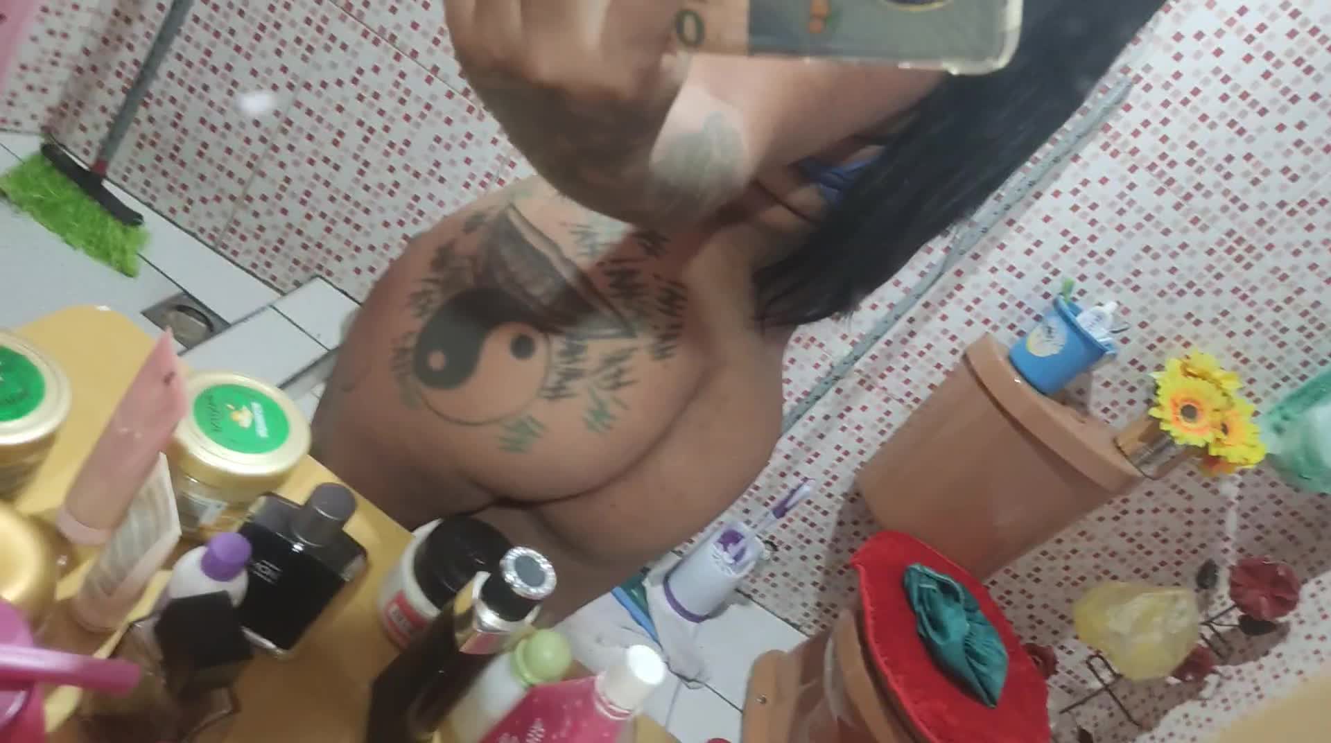Bunda tatuada sensual refletida no espelho