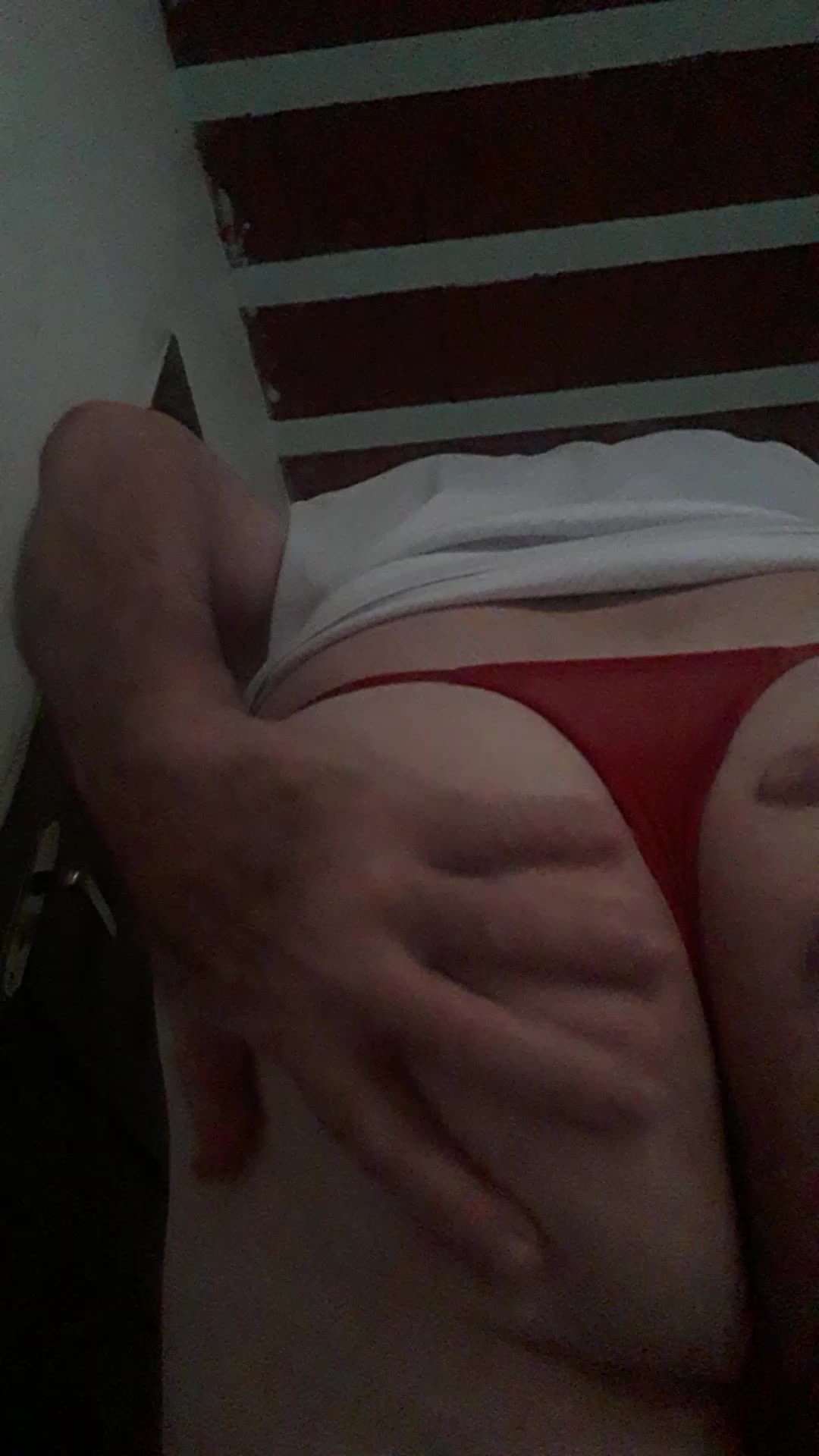 Homem provocante de tanga vermelha massageando bumbum