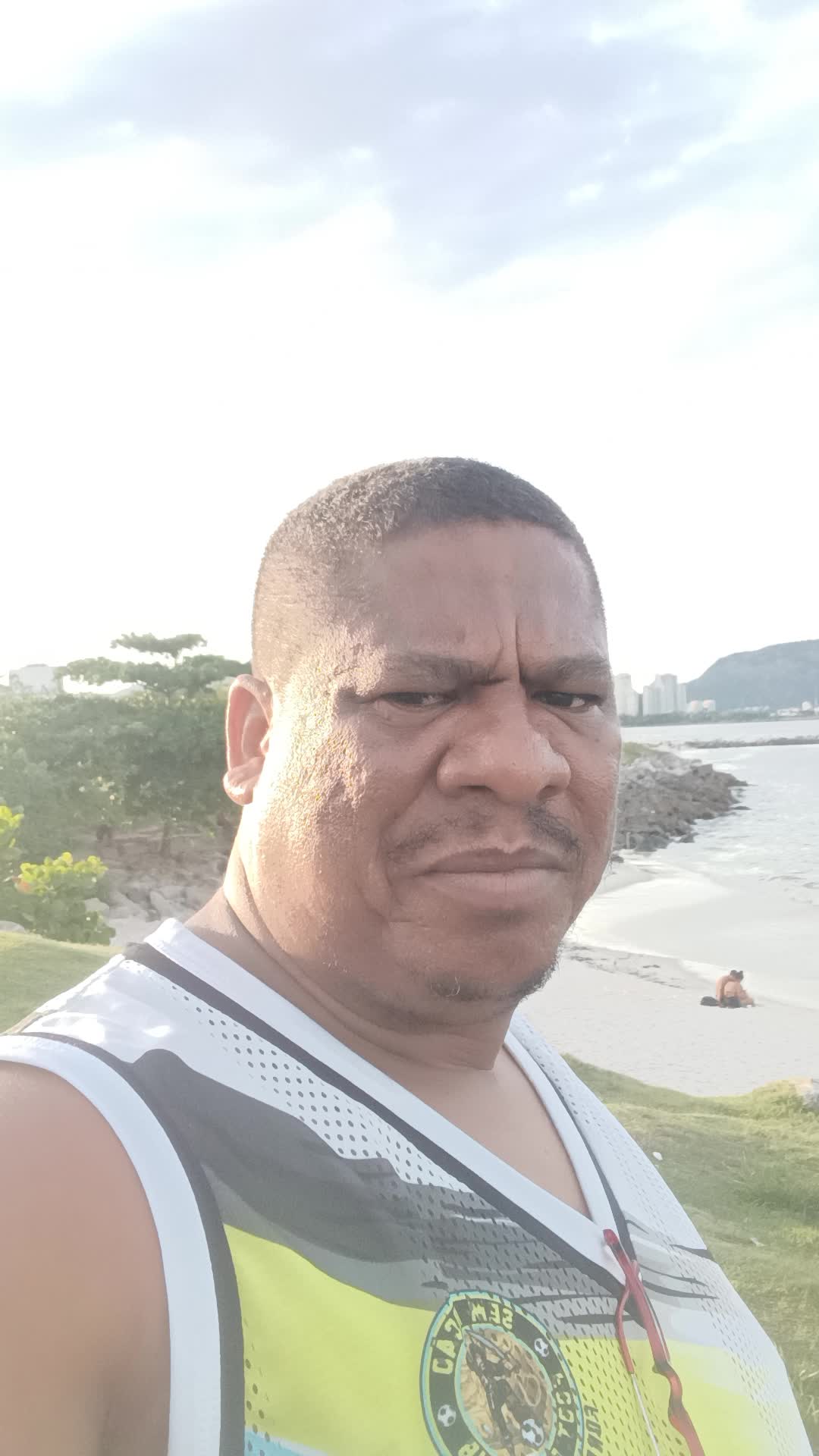 Homem sorrindo na praia, sensualidade e liberdade