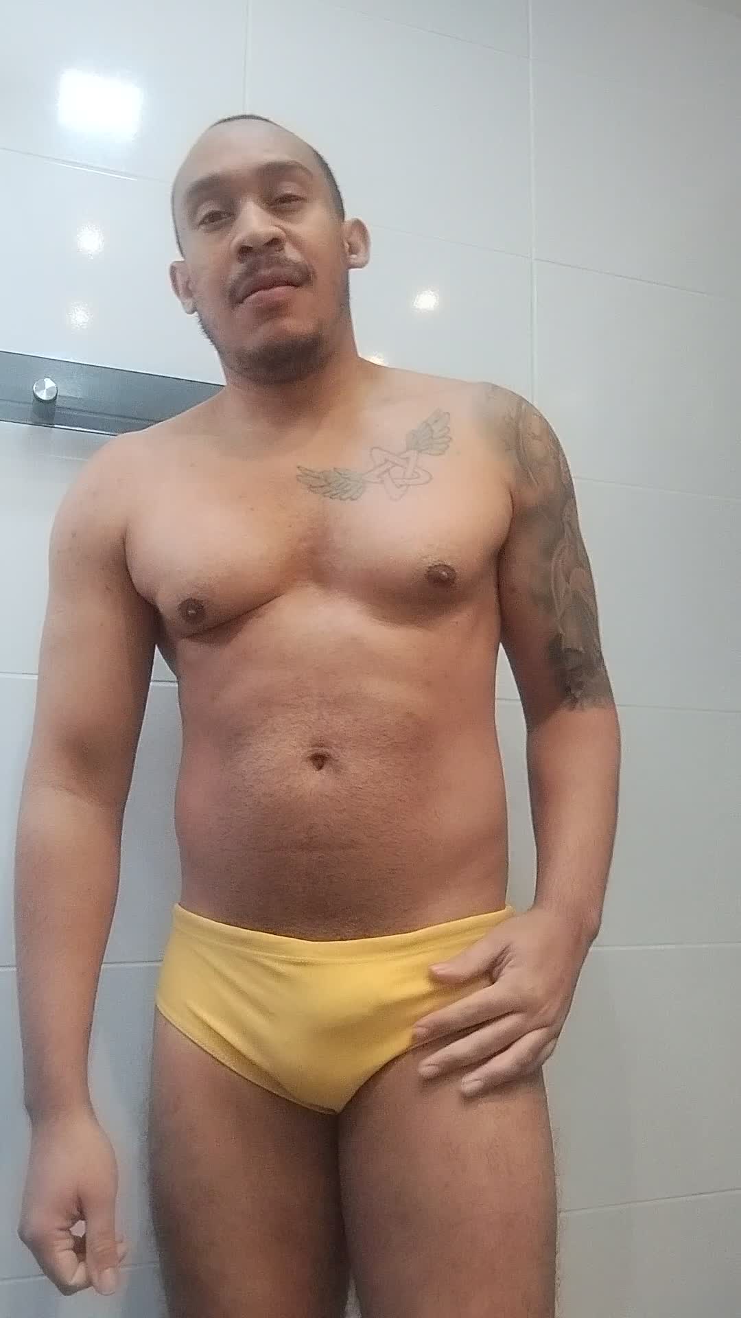 Homem provocante em sunga amarela com fetiches de masturbação e voyeurismo