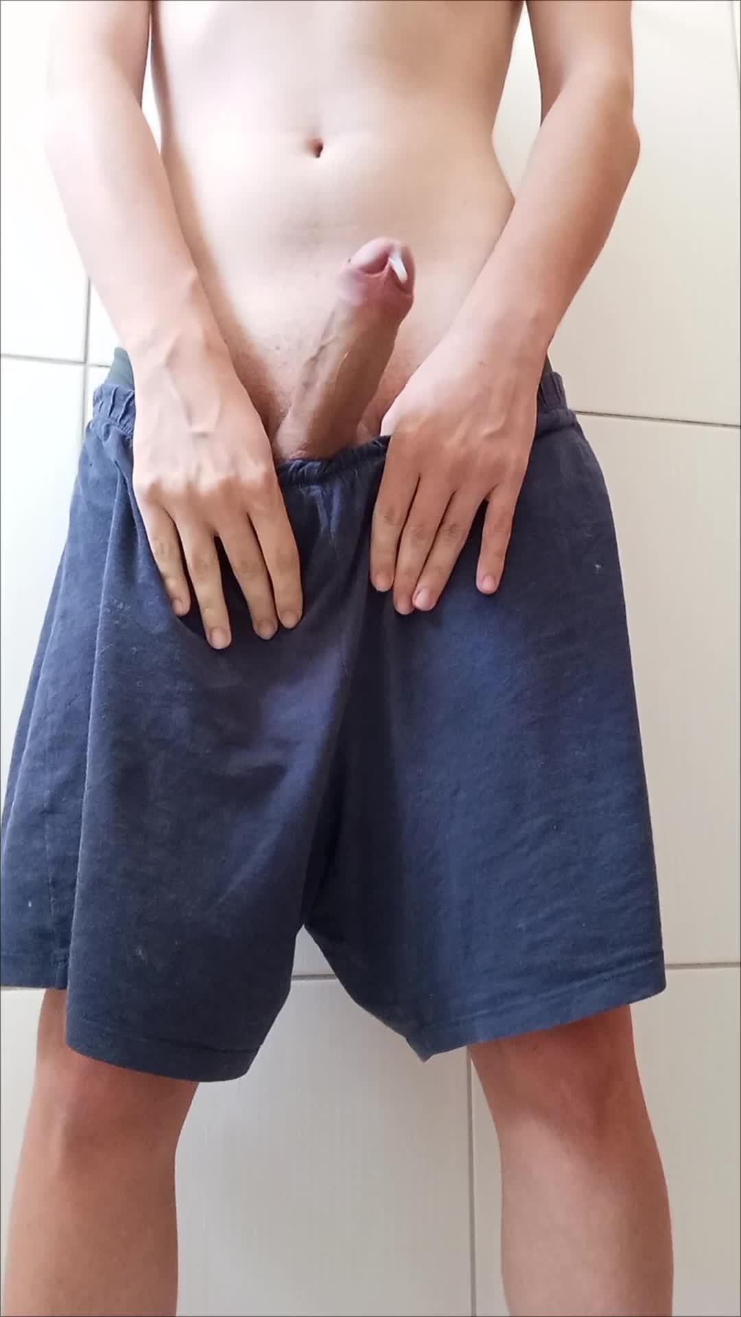 Homem sensual exibindo masturbação em shorts