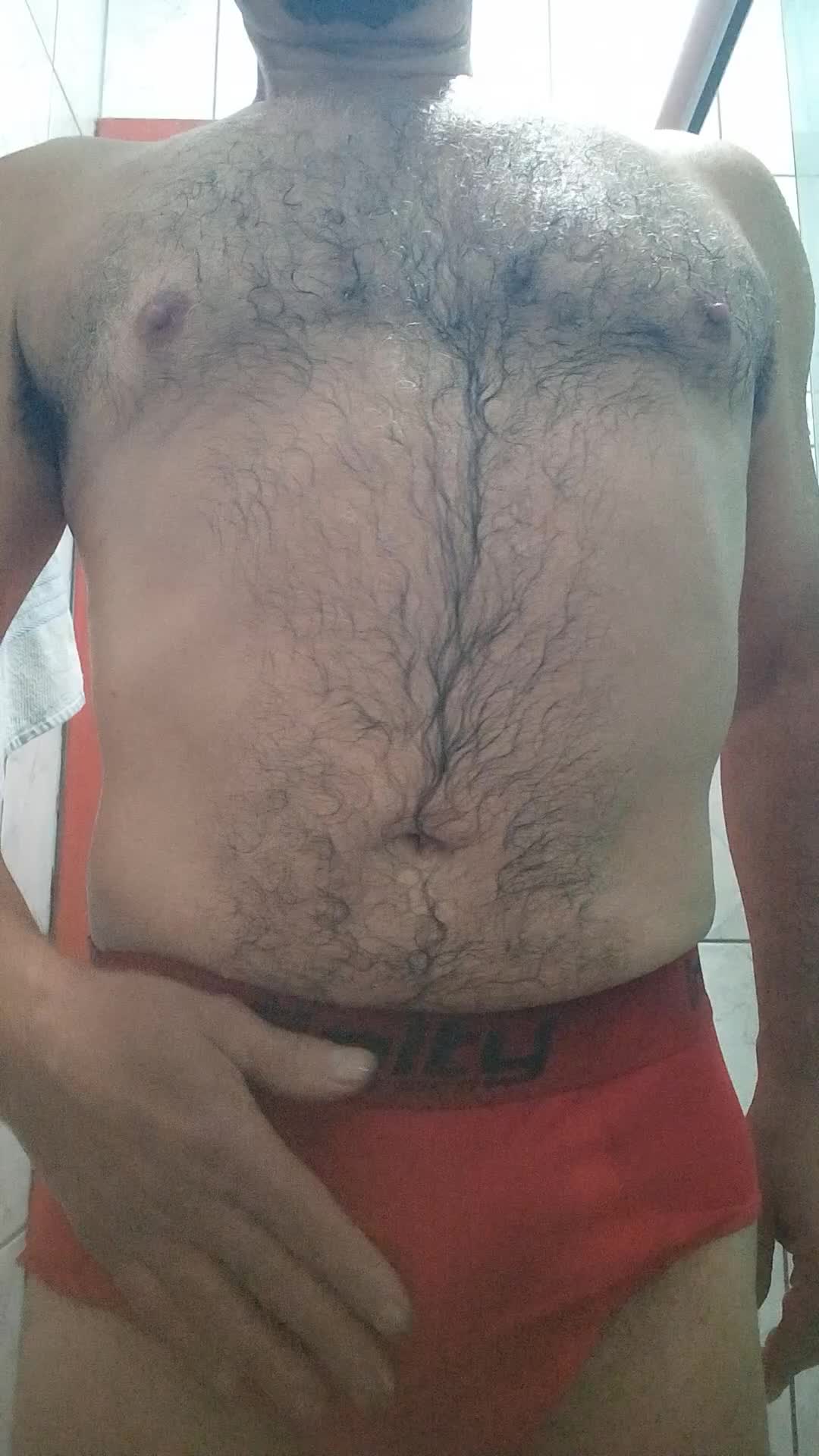 Homem peludo e barbudo em cena de masturbação