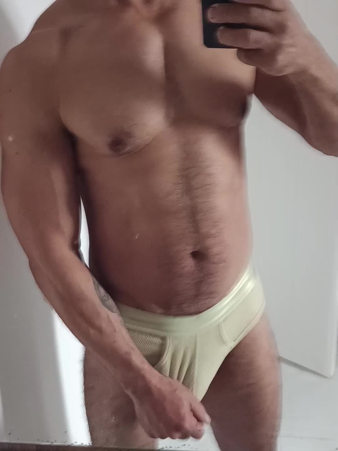 Homem musculoso de cueca exibindo músculos e pênis