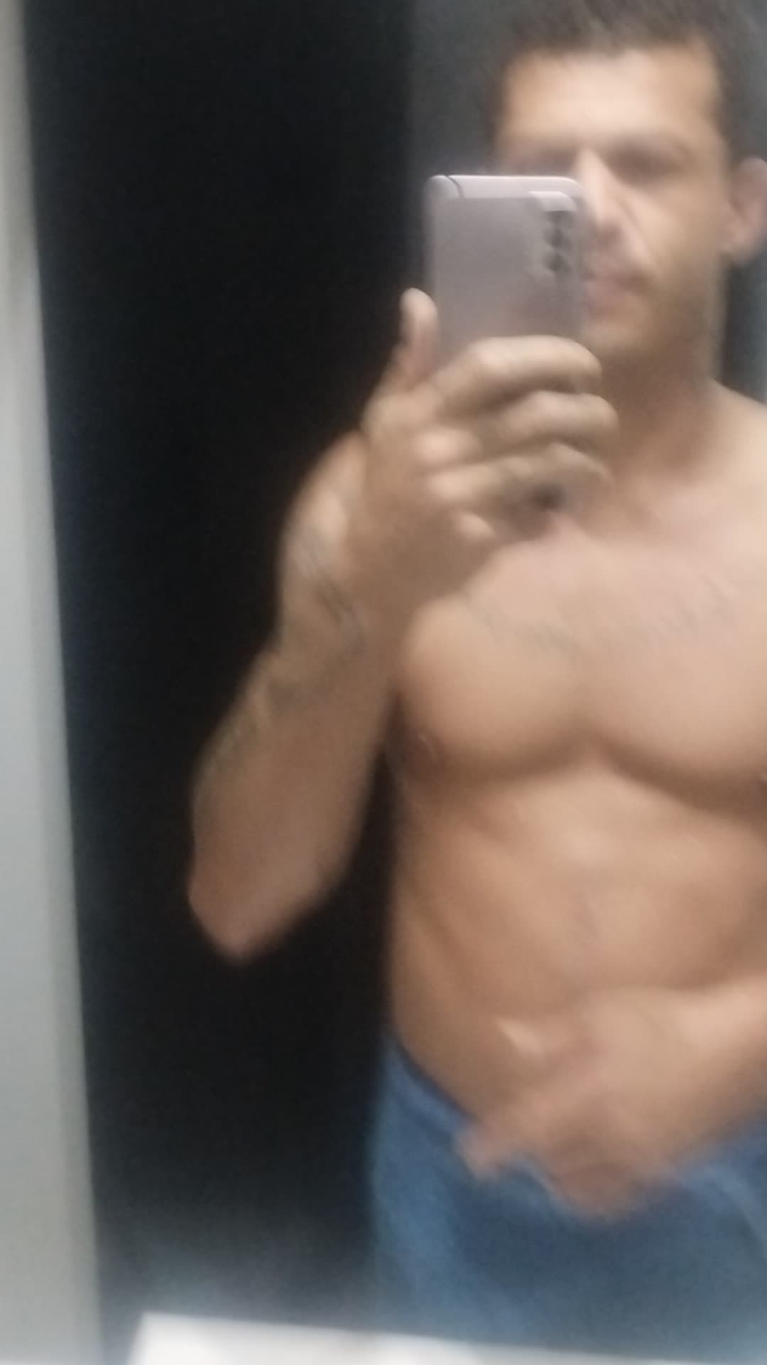 Homem musculoso de toalha em frente ao espelho