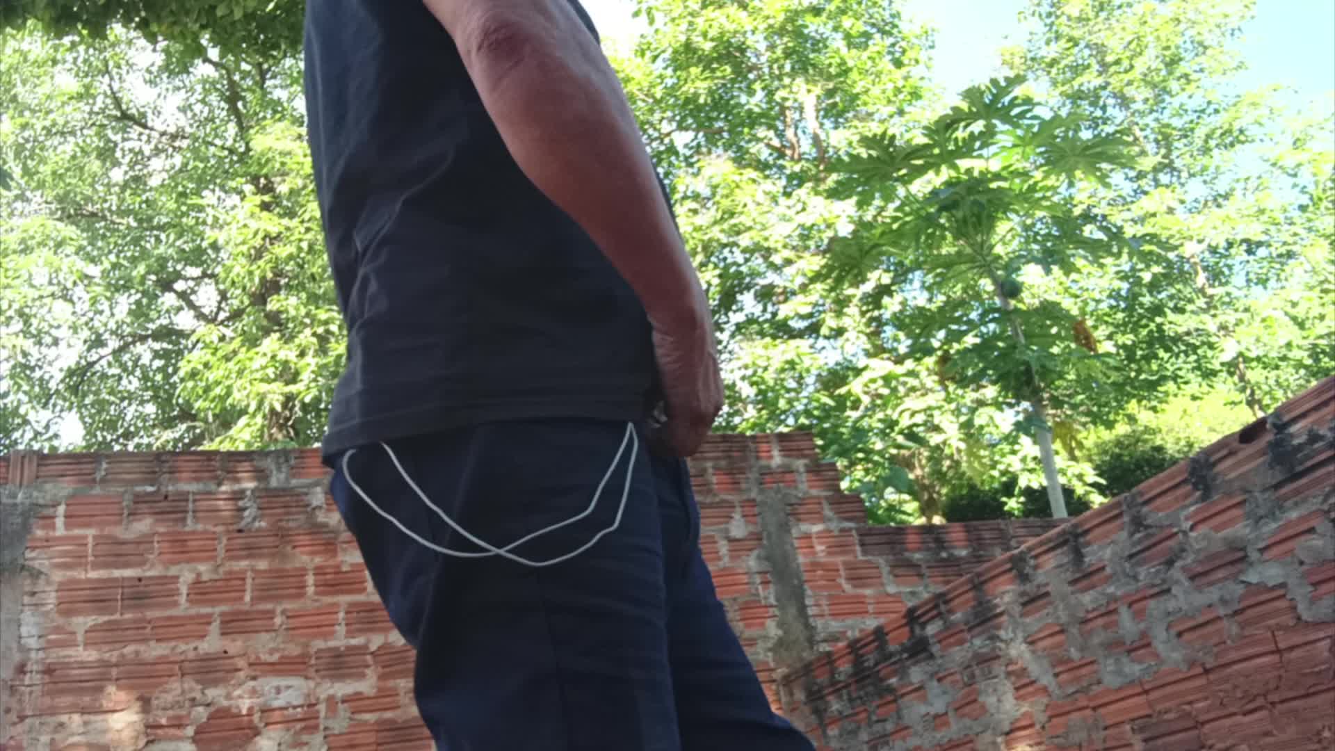 Cena de urofilia com homem urinando em local aberto